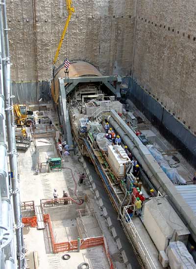 Helicopter birds eye view of a train on route crossing a bridge over a road 