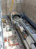 Helicopter birds eye view of a train on route crossing a bridge over a road 